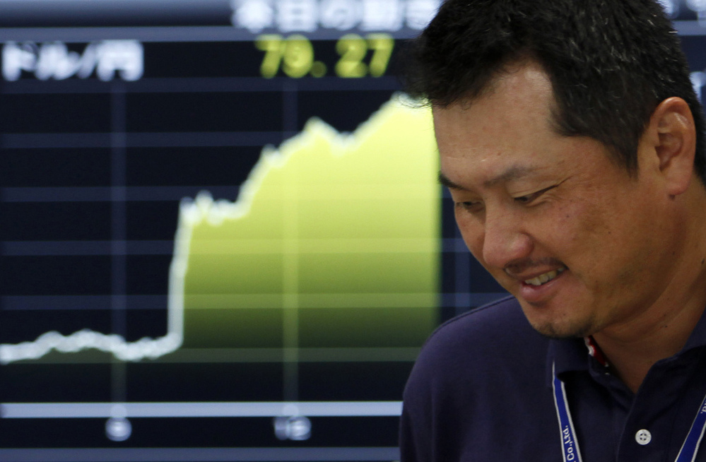 A money trader reacts in front of the  yen-dollar exchange rate at  a money market brokerage firm in Tokyo.