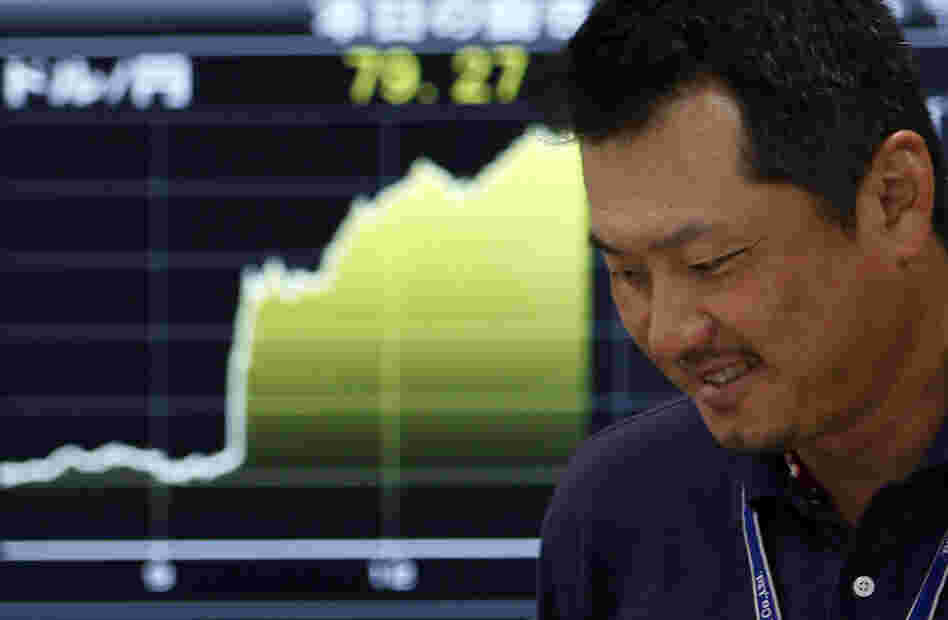 A money trader reacts in front of the  yen-dollar exchange rate at  a money market brokerage firm in Tokyo.