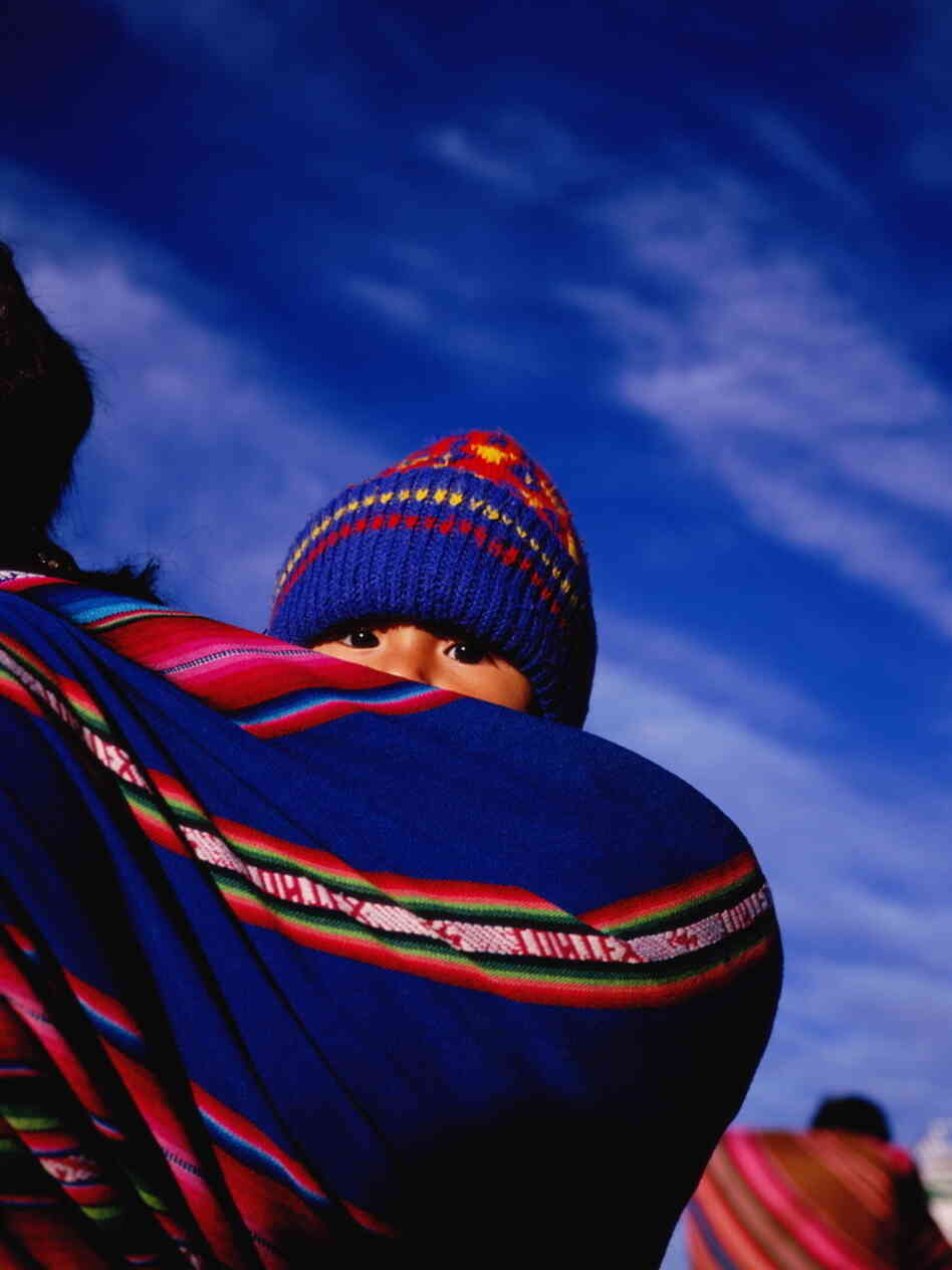 A young child wrapped in an aguayo, a traditional sling, on mother's back in La Paz, Bolivia.