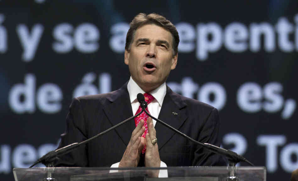 Texas Gov. Rick Perry prays at a daylong rally in Houston on Saturday. Perry attended the prayer rally despite criticism that the event inappropriately mixes religion and politics.