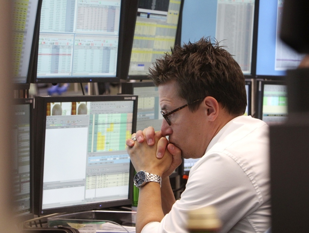 A broker watches screens displaying the German stock index DAX at the stock market in Frankfurt, Germany, on Monday, where the stock index fell after the opening of trading.