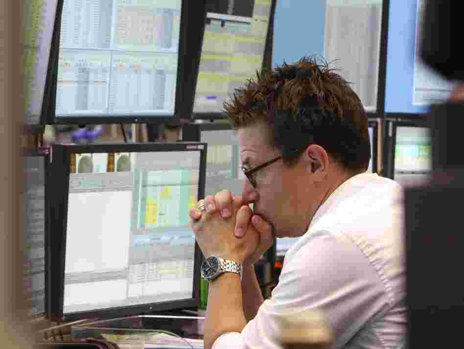 A broker watches screens displaying the German stock index DAX at the stock market in Frankfurt, Germany, on Monday, where the stock index fell after the opening of trading.