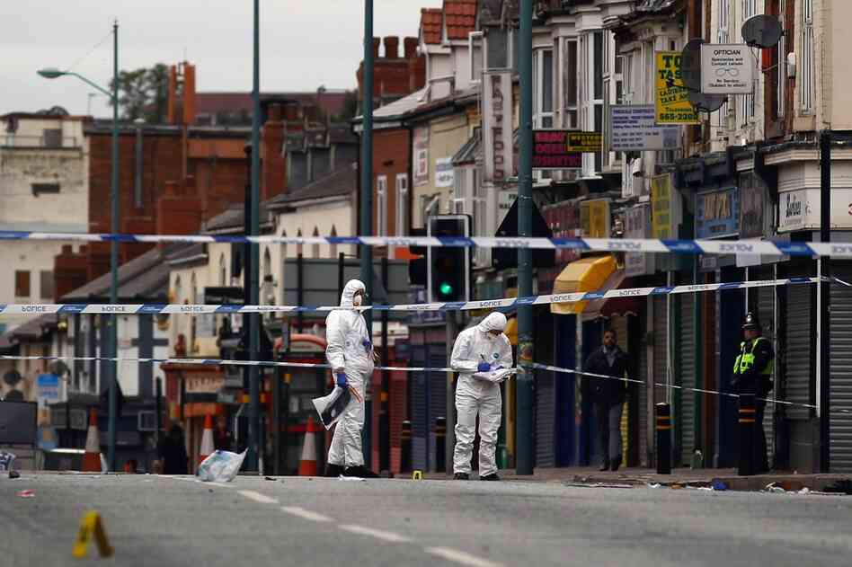 Police collect evidence at the scene where three people were killed after being struck by a vehicle in the Winson Green area on Aug. 10 in Birmingham, England. The three men were allegedly trying to protect local stores from looters. 
