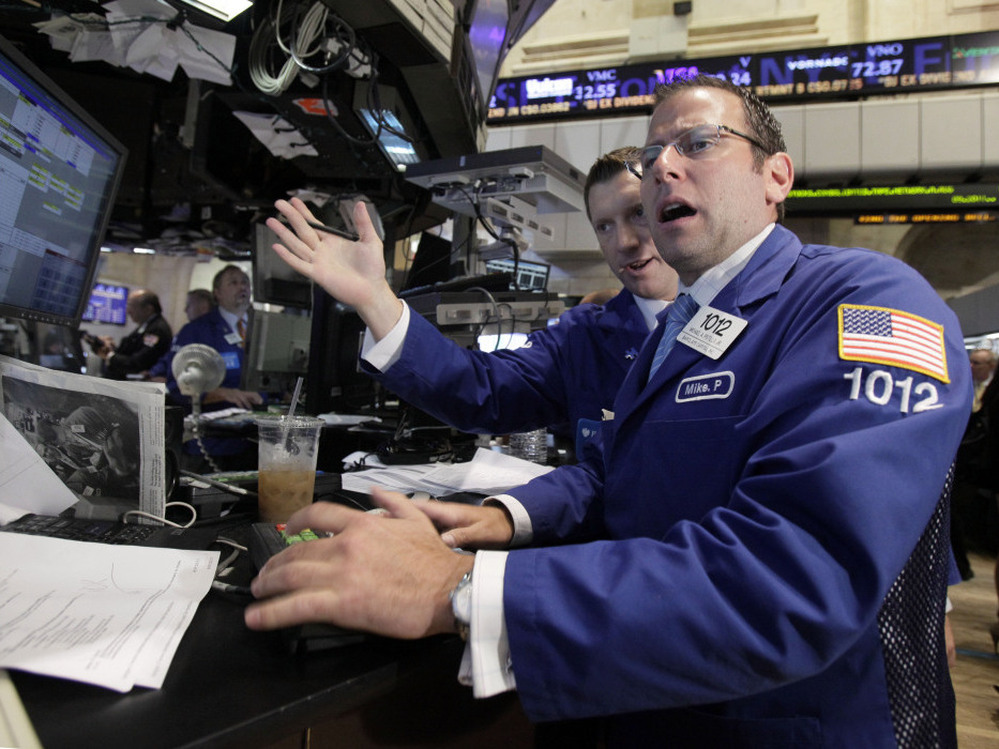 Michael Pistillo, right, works with a fellow specialist on the floor of the New York Stock Exchange Tuesday, Aug. 9, 2011.