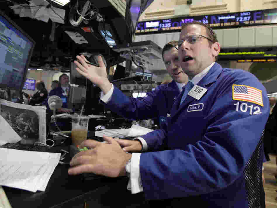 Michael Pistillo, right, works with a fellow specialist on the floor of the New York Stock Exchange Tuesday, Aug. 9, 2011.