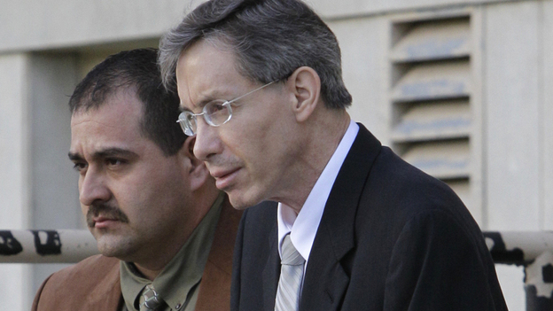 Warren Jeffs, right, is escorted out of the Tom Green County Courthouse by a law enforcement officer.
