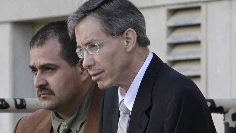 Warren Jeffs, right, is escorted out of the Tom Green County Courthouse by a law enforcement officer.