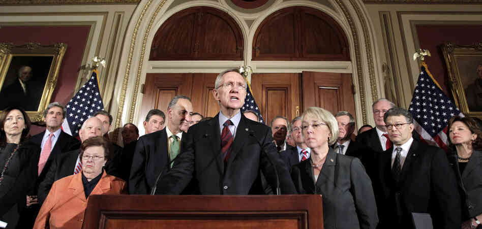 Senators Harry Reid with Patty Murray to his left, Max Baucus over her left shoulder and John Kerry second from left.