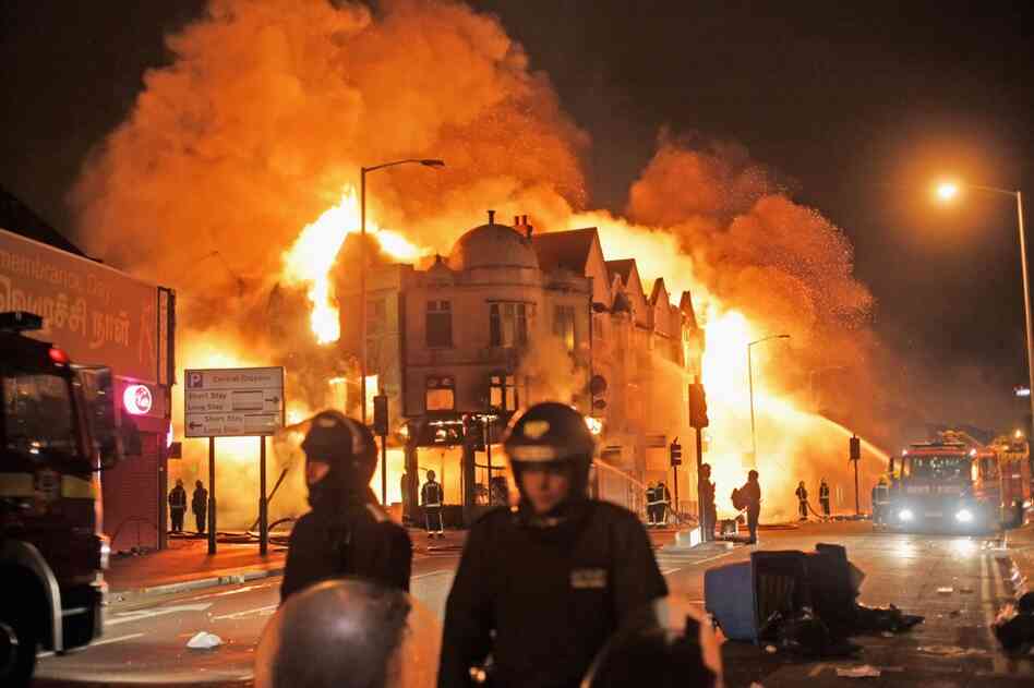 In the early hours of Aug. 9, firefighters in London battle a large fire that broke out in shops and residential properties. Looting and clashes with police continued for a third day in parts of the capital city after a fatal police shooting under disputed circumstances killed Mark Duggan, a 29-year-old father of four, on Aug. 4. 