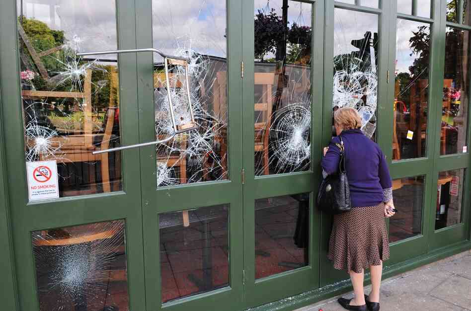 A chair is left embedded in a restaurant window on Aug. 9 following a night of rioting in the Haven Green area of Ealing, another suburb of London. 