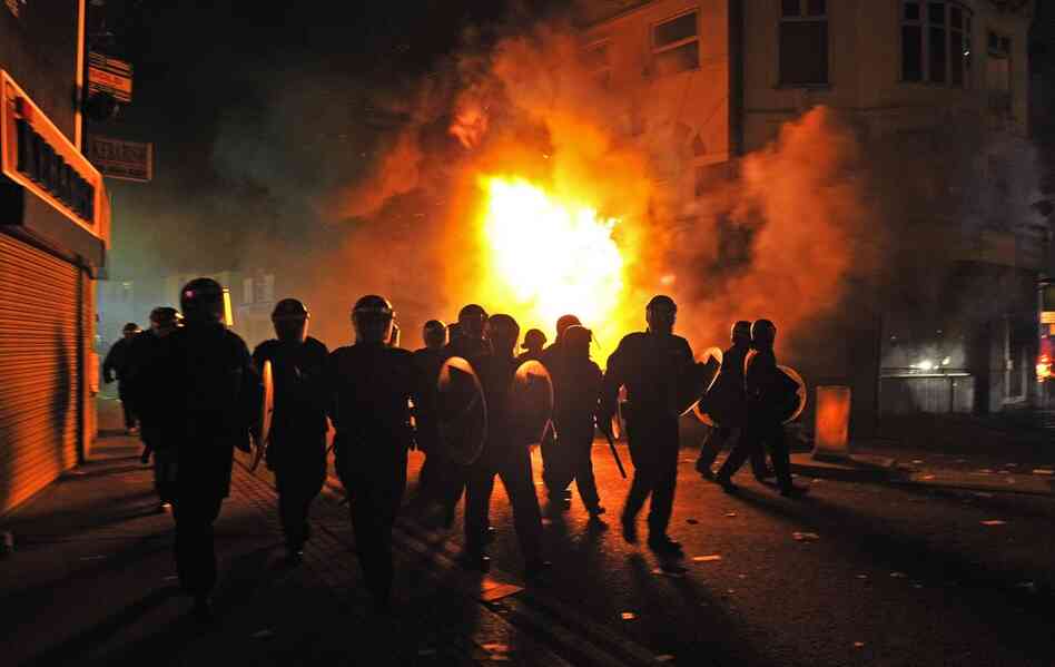 Riot police patrol the street in Croydon on Aug. 8. Numerous buildings were set on fire in the South London suburb, including a 140-year-old furniture store. 