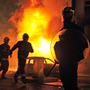 A British riot policeman stands guard in front of a burning building and burnt out car in Croydon, South London on August 8, 2011. A British riot policeman stands guard in front of a burning building and burnt out car in Croydon, South London on August 8, 2011.