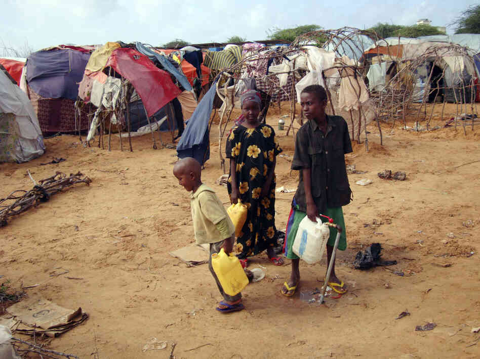 Children from southern Somalia fill jugs with water at a refugee camp in Mogadishu Tuesday. The number of people fleeing famine-hit areas of Somalia is likely to rise dramatically and could overwhelm international aid efforts in the Horn of Africa, a U.N. aid official said Tuesday.