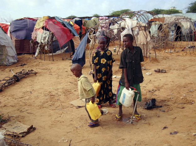 Children from southern Somalia fill jugs with water at a refugee camp in Mogadishu Tuesday. The number of people fleeing famine-hit areas of Somalia is likely to rise dramatically and could overwhelm international aid efforts in the Horn of Africa, a U.N. aid official said Tuesday.