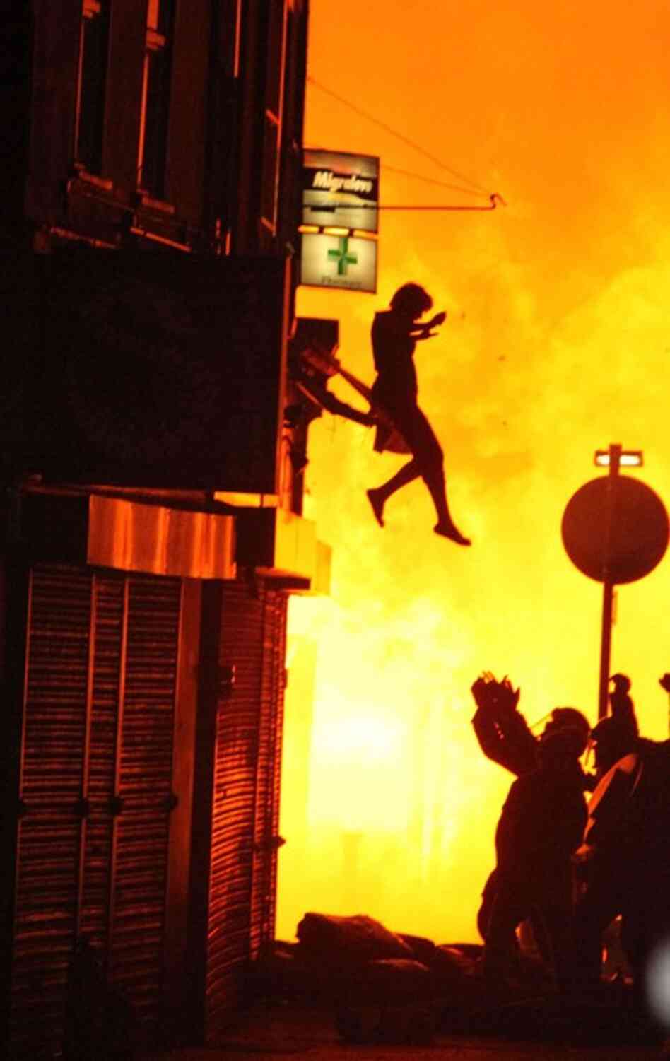 A woman can be seen jumping from a burning building in Croydon on Aug. 8. 