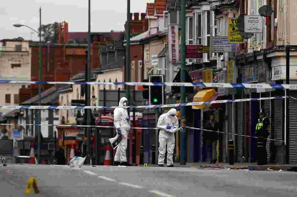 Police collect evidence at the scene where three people were killed after being struck by a vehicle in the Winson Green area on Aug. 10 in Birmingham, England. The three men were allegedly trying to protect local stores from looters. 