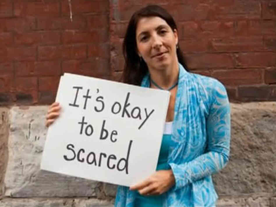 One of women in the video holds up a sign that says, "It's okay to be scared." One of women in the video holds up a sign that says, "It's okay to be scared."