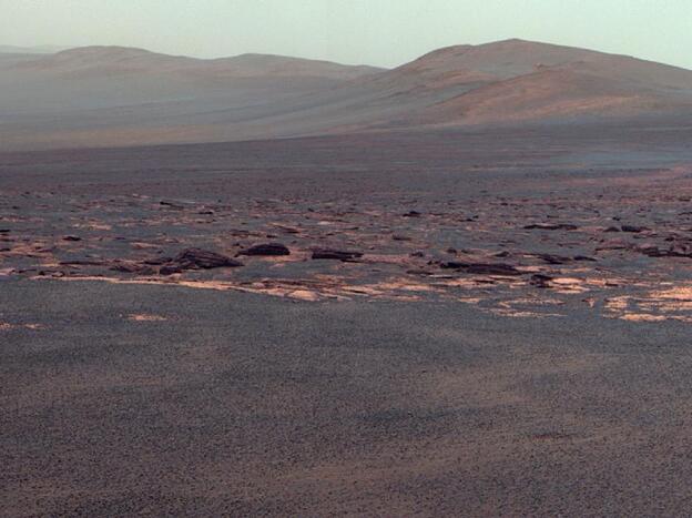 A portion of the west rim of Endeavour crater sweeps southward in this view from NASA's Mars Exploration Rover Opportunity. NASA adjusted the colors in this image. Fans of the film Capricorn One may want to see the original orange-tinted image.