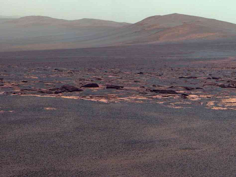 A portion of the west rim of Endeavour crater sweeps southward in this view from NASA's Mars Exploration Rover Opportunity. NASA adjusted the colors in this image. Fans of the film Capricorn One may want to see the original orange-tinted image.