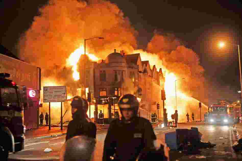 In the early hours of Aug. 9, firefighters in London battle a large fire that broke out in shops and residential properties. Looting and clashes with police continued for a third day in parts of the capital city after a fatal police shooting under disputed circumstances killed Mark Duggan, a 29-year-old father of four, on Aug. 4. 