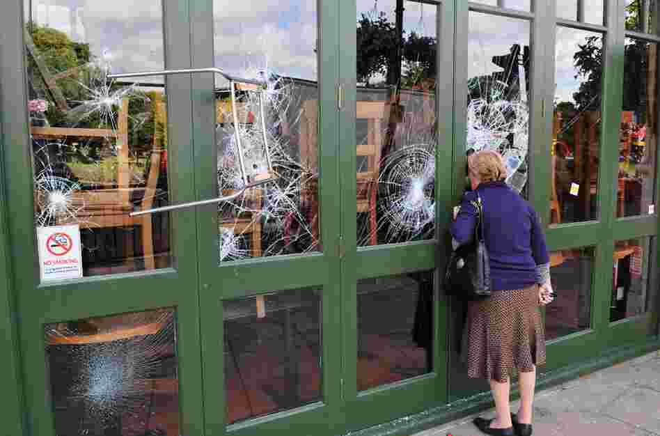 A chair is left embedded in a restaurant window on Aug. 9 following a night of rioting in the Haven Green area of Ealing, another suburb of London. 