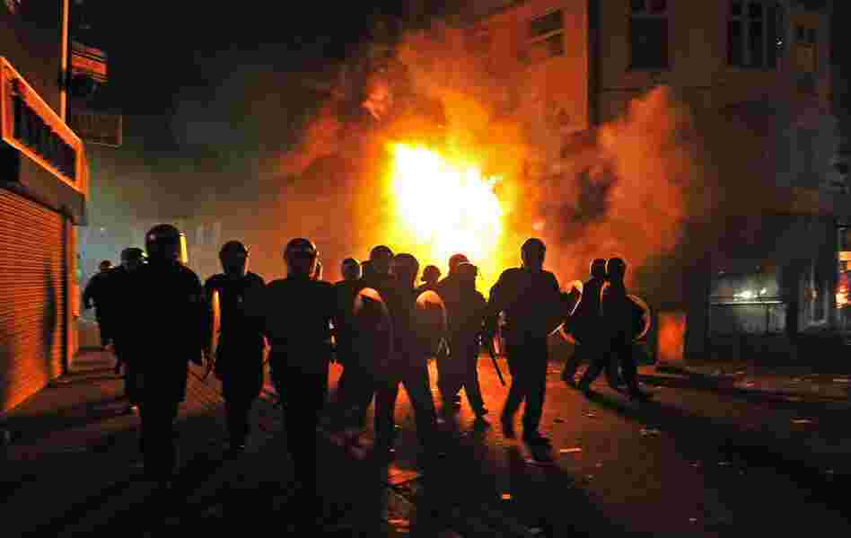 Riot police patrol the street in Croydon on Aug. 8. Numerous buildings were set on fire in the South London suburb, including a 140-year-old furniture store. 