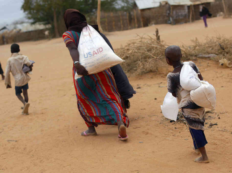 A Somali family carries their supply of food aid as they arrive at a refugee camp outside Dadaab in northeastern Kenya along the Somali border, Aug. 5, 2011. A Somali family carries their supply of food aid as they arrive at a refugee camp outside Dadaab in northeastern Kenya along the Somali border, Aug. 5, 2011.