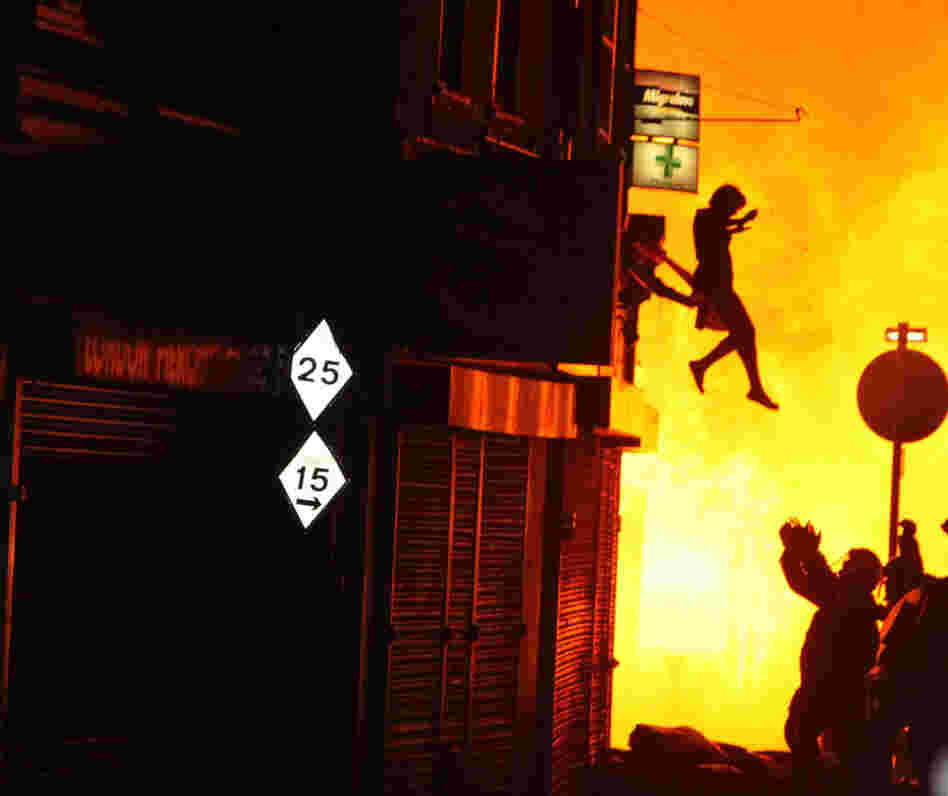 After hearing people shout that a woman was about to jump from a burning building, photographer Amy Weston snapped this image of the woman's leap to safety.