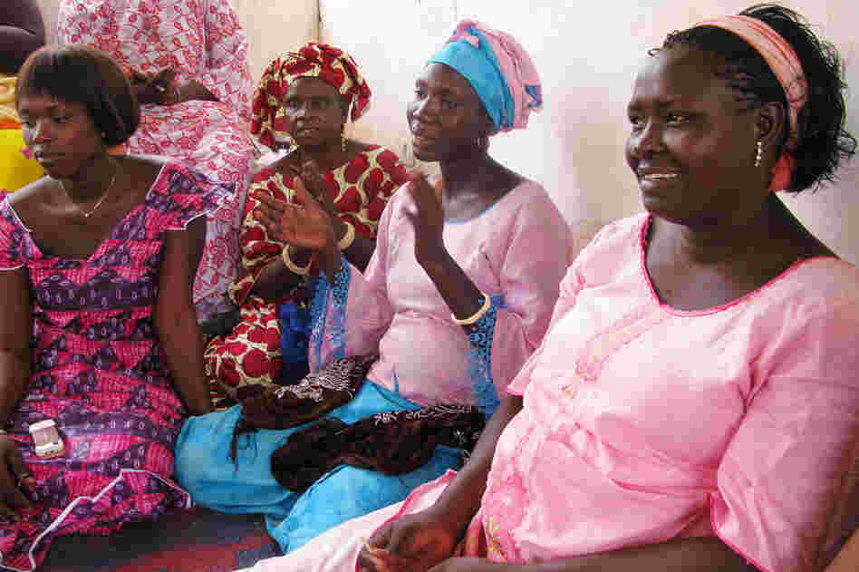 Pregnant younger women, dressed in pink, share with the older women things they have learned about prenatal care from aid groups like ChildFund.