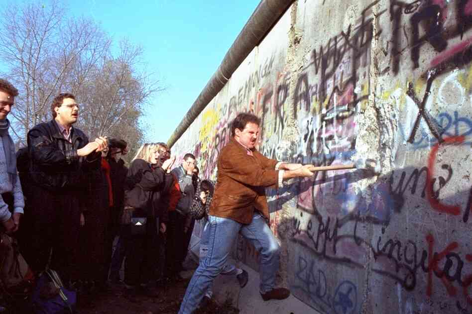 A West Berliner swings a sledgehammer into the wall on Nov. 12, 1989. 