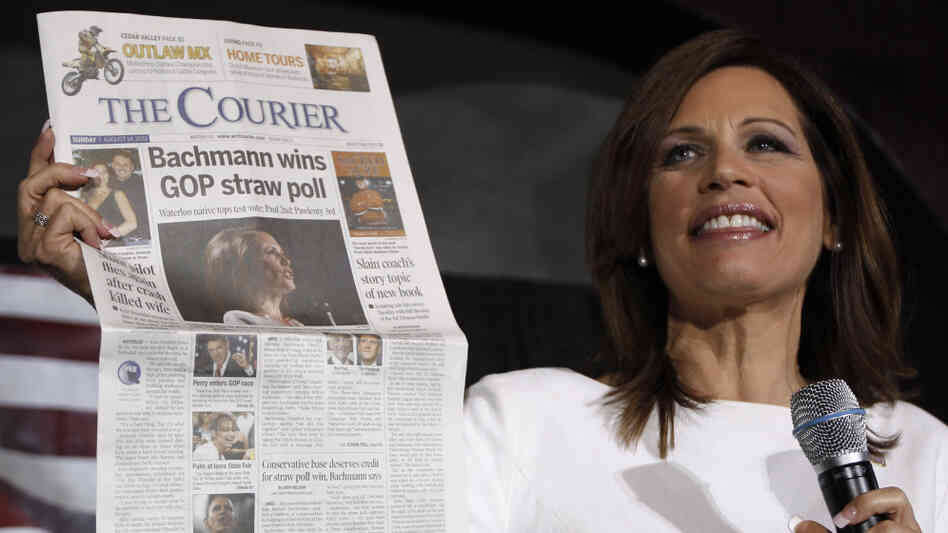 Republican presidential candidate Rep. Michele Bachmann, R-Minn., holds up a newspaper saying that she won the GOP Straw Poll as she speaks at the Black Hawk County Republican Party Lincoln Day Dinner in Waterloo, Iowa, Sunday, Aug. 14, 2011. (AP Photo/Charles Dharapak)