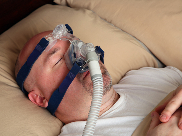 Many people with sleep apnea wear a CPAP machine mask in bed to help them breathe.