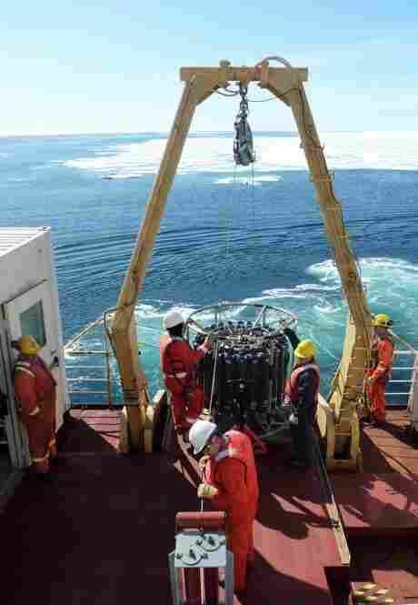 Crew members lower a rosette sampler into the chilly waters to check temperature and salinity — one of many science experiments carried out on the Louis.