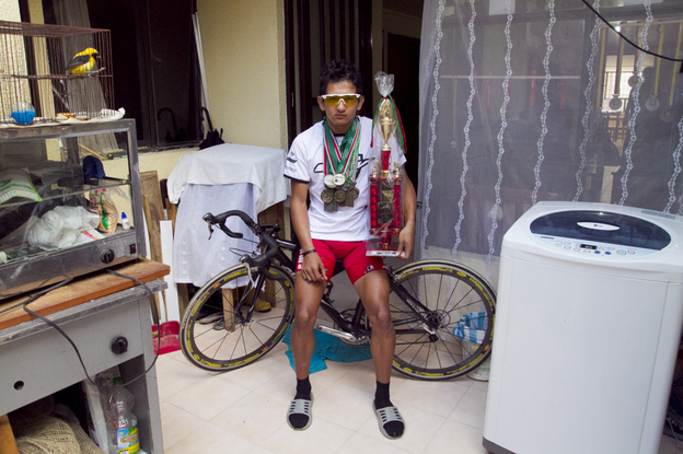Johan Cardenas, 16, poses with his medals, one of his three bikes and one of his several trophies in his home in Duitama, Colombia. The promising young rider hopes to join the ranks of world-class cyclists from Colombia — who are known for their ability to withstand pain.