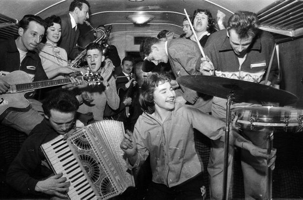 February 1957:  Bill Haley's band The Comets play in the cramped space of a railway carriage en route to London.  (Photo by Harry Kerr/BIPs/Getty Images)