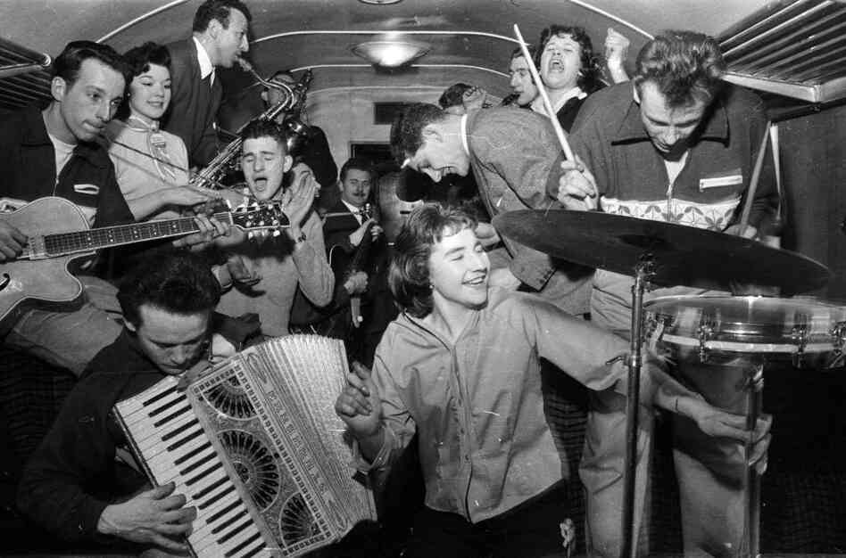 February 1957:  Bill Haley's band The Comets play in the cramped space of a railway carriage en route to London.  (Photo by Harry Kerr/BIPs/Getty Images)