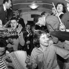 February 1957:  Bill Haley's band The Comets play in the cramped space of a railway carriage en route to London.  (Photo by Harry Kerr/BIPs/Getty Images)