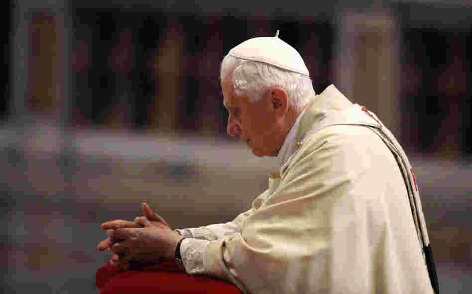 Pope Benedict XVI prays in front of the coffin of his predecessor, John Paul II, at St. Peter's Basilica at the end of a beatification ceremony on May 1, 2011, in Vatican City.