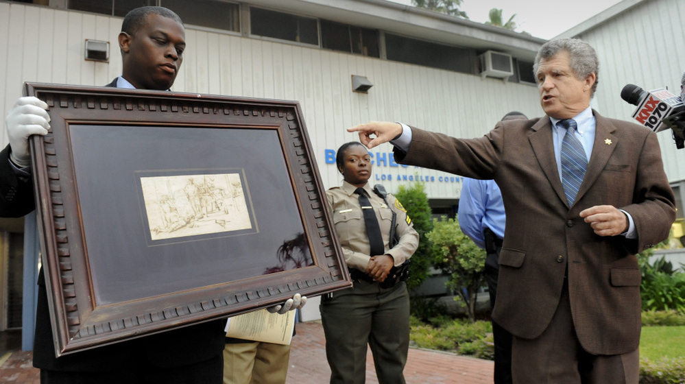 Los Angeles Sheriff lead detective Clarence Williams, left,  and Los Angeles County sheriff's spokesman Steve Whitmore, right, display the recovered $250,000 quill pen Rembrandt drawing known as "The Judgment."