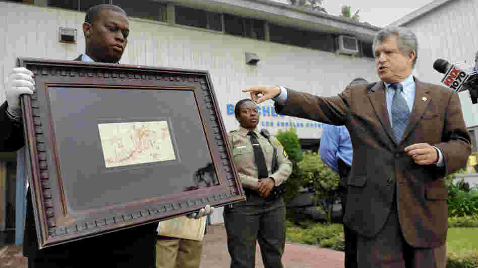 Los Angeles Sheriff lead detective Clarence Williams, left,  and Los Angeles County sheriff's spokesman Steve Whitmore, right, display the recovered $250,000 quill pen Rembrandt drawing known as "The Judgment."