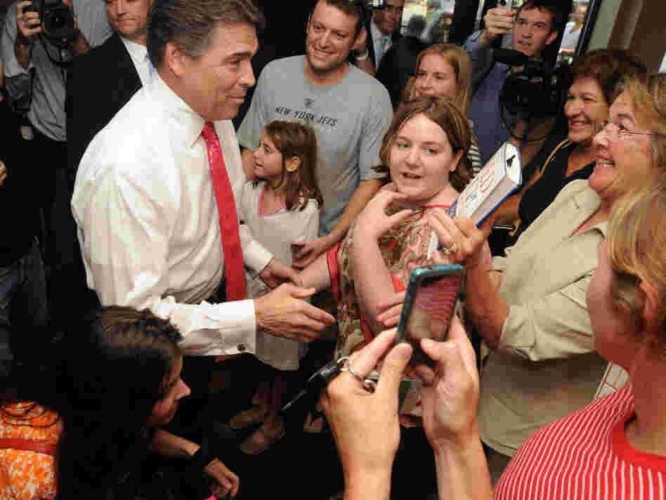 Texas Gov. Rick Perry, who recently joined the GOP presidential race, speaks Thursday with patrons at Popovers in Portsmouth, N.H.