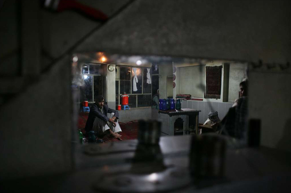 A few Afghans wait for electricity in order to watch television at a tea house in Afghanistan's Takhar province.