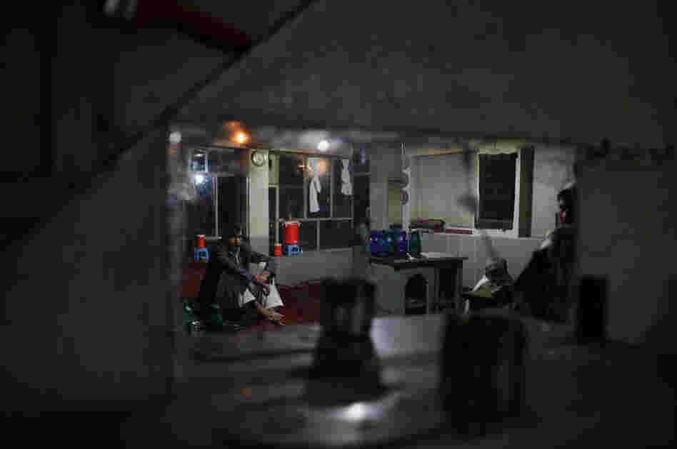 A few Afghans wait for electricity in order to watch television at a tea house in Afghanistan's Takhar province.