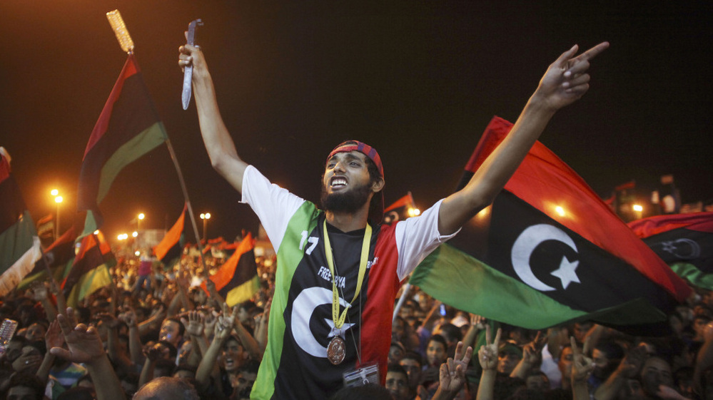 People celebrate the capture in Tripoli of Moammar Gadhafi's son and one-time heir apparent, Seif al-Islam, at the rebel-held town of Benghazi, Libya, early Monday. Libyan rebels raced into Tripoli in a lightning advance Sunday that met little resistance as Gadhafi's defenders melted away and his 42-year rule appeared to rapidly crumble.
