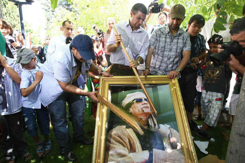Demonstrators smash a portrait of Moammar Gadhafi during a protest in Ankara on Monday. 