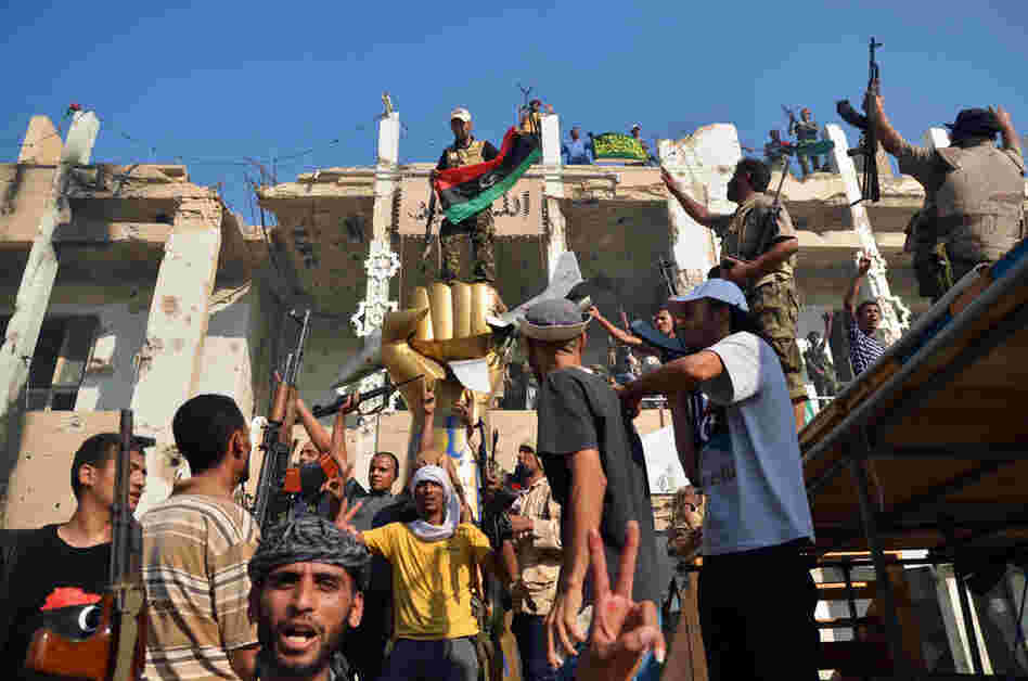 Rebels celebrate around the iconic statue of a golden fist crushing a U.S. military bomber in Tripoli on Wednesday. 