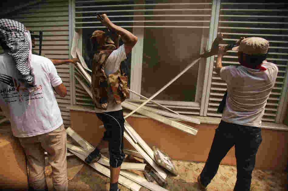 Rebels break into a living room at Gadhafi's compound. 