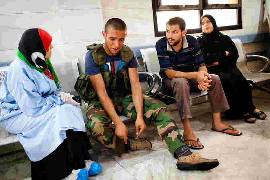 A rebel soldier reacts after a fellow fighter was brought in with a wound sustained in battle with fighters loyal to longtime leader Moammar Gadhafi at Tripoli Central Hospital. 