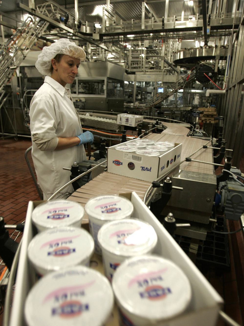 A worker monitors the production line as cases of Fage yogurt are produced in Johnstown, N.Y., in 2008. Fage and Chobani lead the pack of best-selling Greek-style yogurt brands.