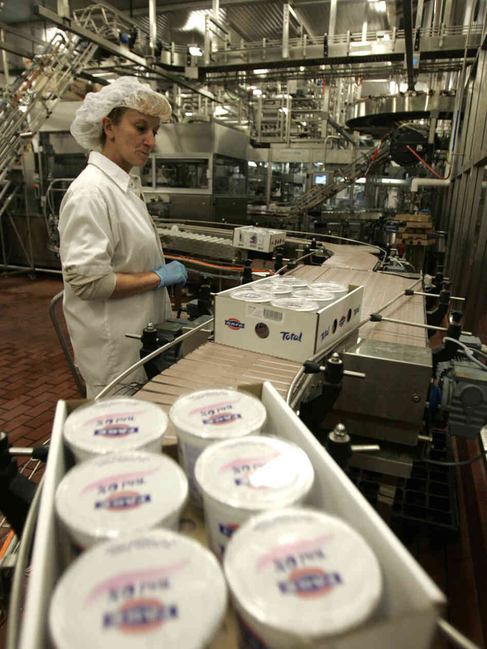 A worker monitors the production line as cases of Fage yogurt are produced in Johnstown, N.Y., in 2008. Fage and Chobani lead the pack of best-selling Greek-style yogurt brands.